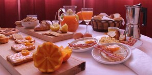A breakfast table with various foods and drinks, including toast, eggs, bacon, and orange juice. - Bed and Breakfast Piano Del Re (Partinico)