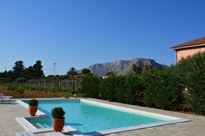 A swimming pool with a mountain backdrop, surrounded by greenery and a fence. - Bed and Breakfast Piano Del Re (Partinico)