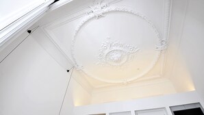 A white ceiling with ornate plasterwork and a recessed light fixture. - La Casa de Antonio Boutique Rooms (Barcelona)