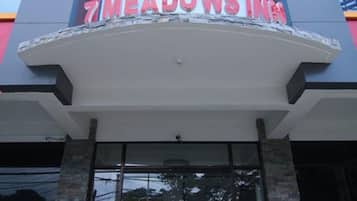 A hotel entrance with a prominent sign reading "7 MEADOWS INN".