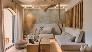 A modern living room with a sofa, wooden coffee table, and a hanging light fixture.