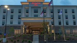 A Hampton Inn hotel with a modern facade, a well-lit entrance, and American flags. - Hampton Inn Black Mountain (Black Mountain)