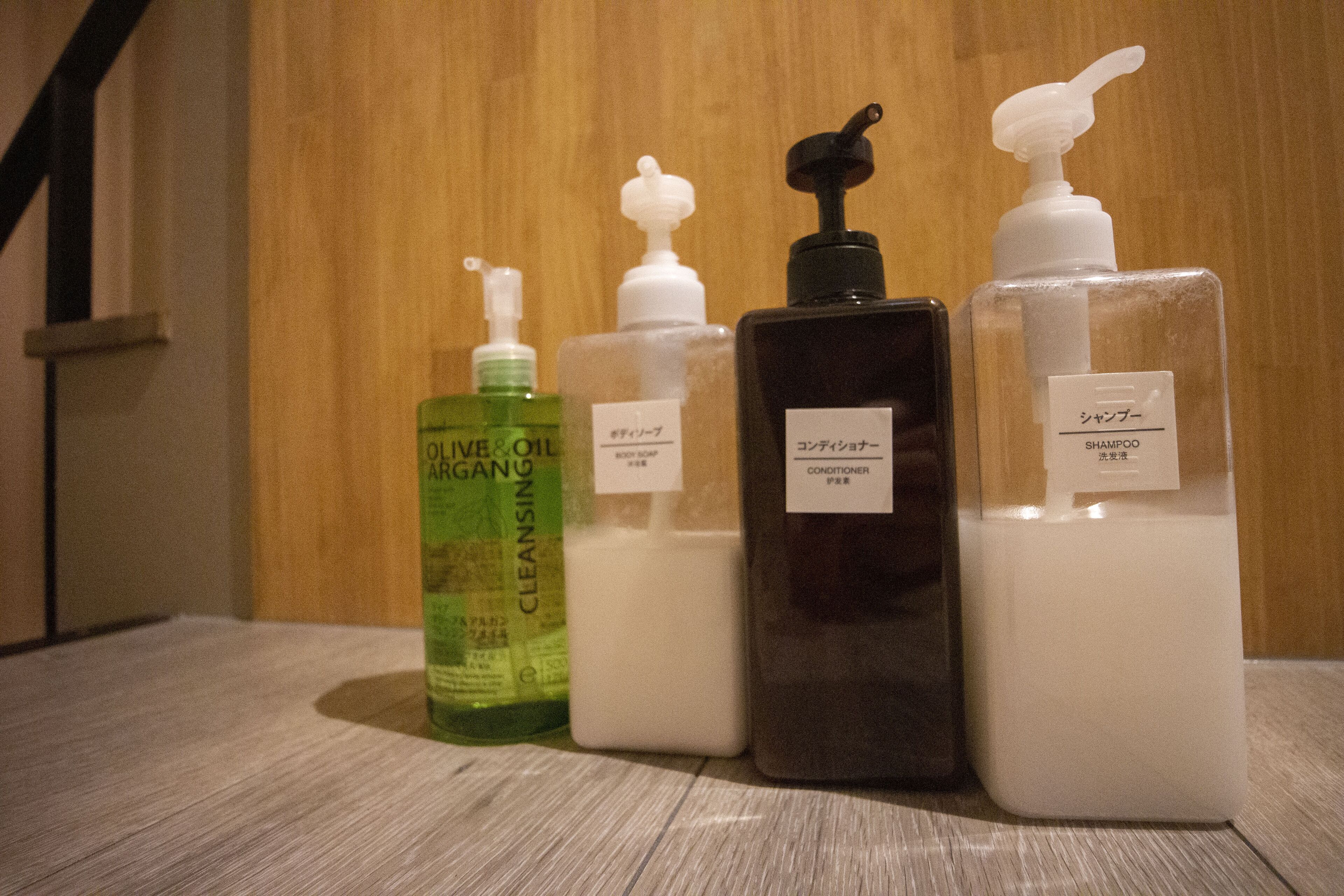 Four bottles of liquid on a wooden surface.