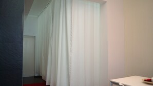A hotel room with a white curtain, a red carpet, and a white table with a plate of fruit. - Relax in Between Alfama and Graça! (Lisboa)