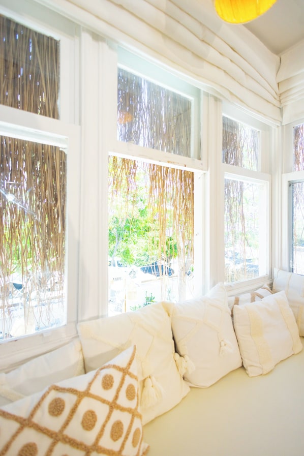 A room with a large bed, white bedding, and multiple windows with sheer curtains. - Sante Alacati (Cesme)