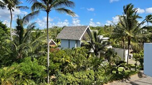 A tropical resort with multiple bungalow-style buildings surrounded by lush greenery and palm trees. - Mont Choisy Le Parc by Pam Golding (Mont Choisy)