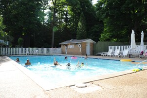 Una piscina al aire libre de temporada, sombrillas