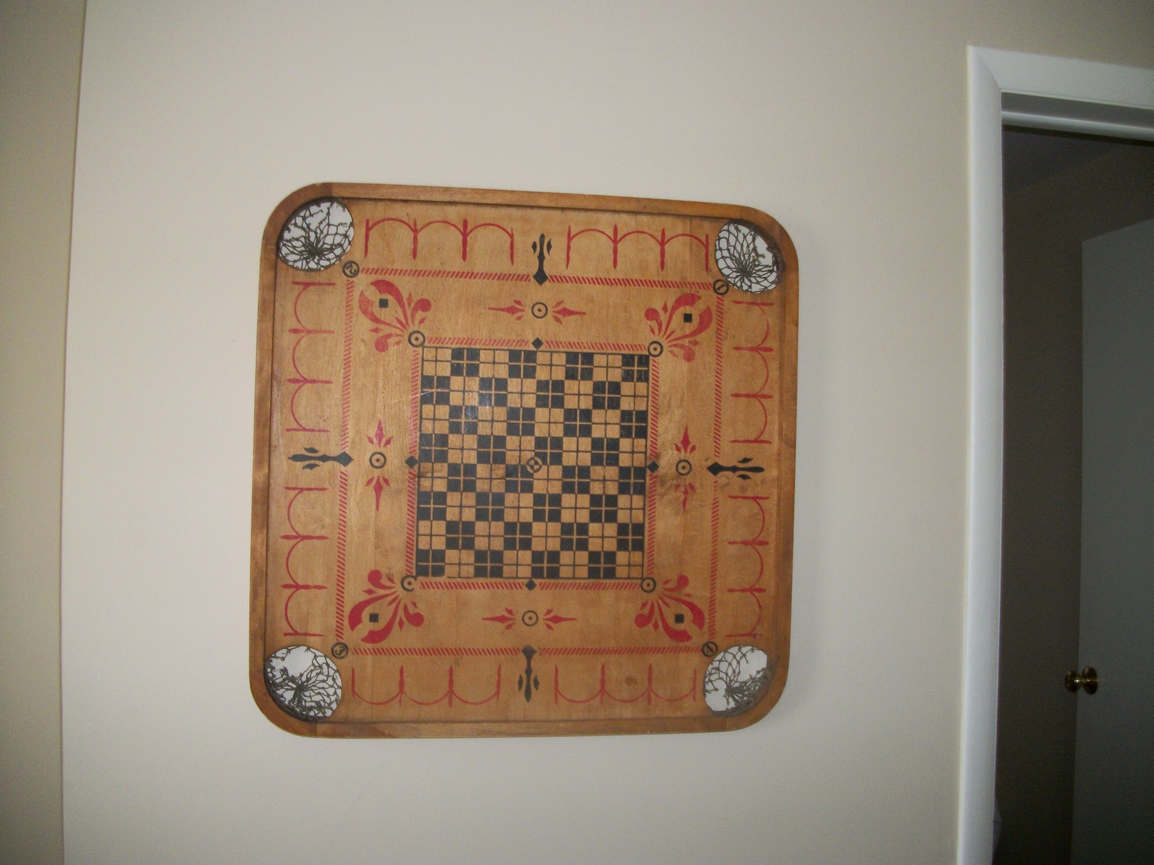 Un tablero de ajedrez con un diseño en cuadros y elementos decorativos en una pared.