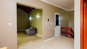 A hallway with a tiled floor, a door, and a staircase.