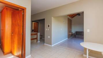 A spacious hallway with a wooden door, a white table, and a sofa in the background.