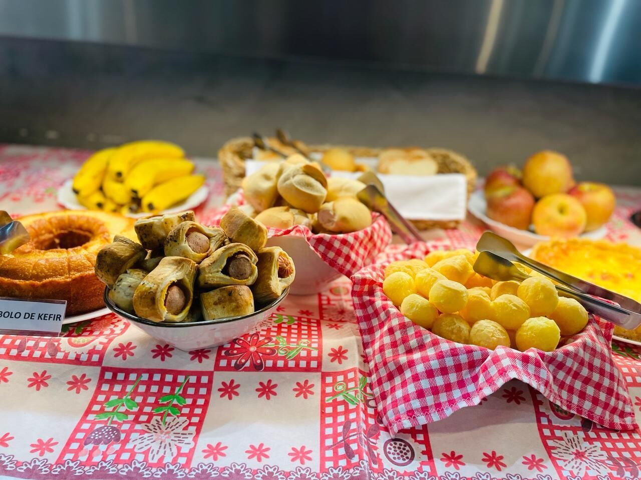 Una mesa con diversos alimentos, incluyendo un pastel Bundt, rosquillas fritas y pasteles amarillos.