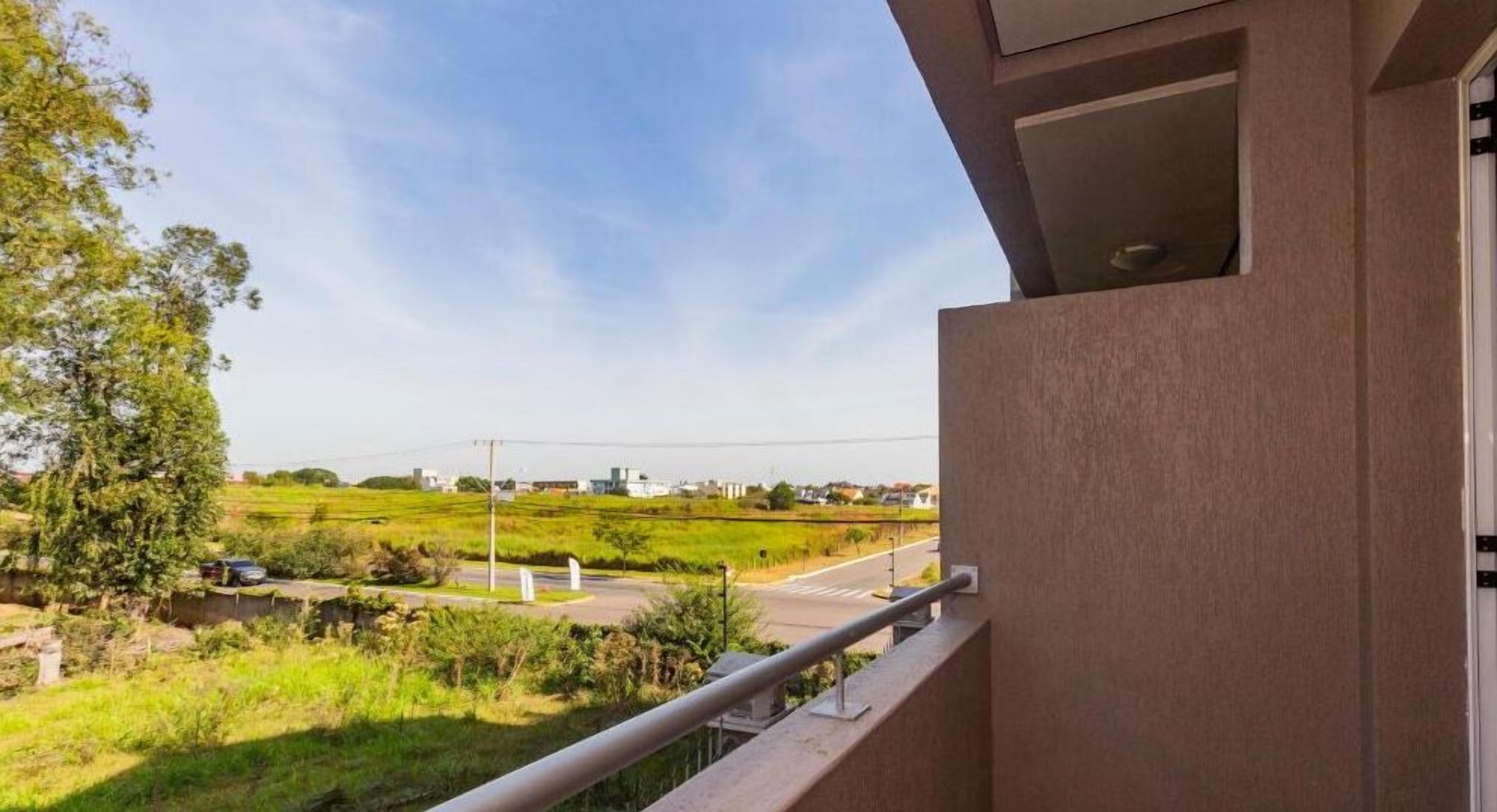 Varanda com vista para uma estrada e vegetação.