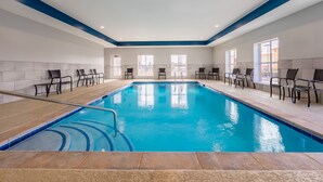 An indoor swimming pool with clear blue water, surrounded by black chairs and a tiled floor. - Candlewood Suites Cookeville by IHG (Cookeville)