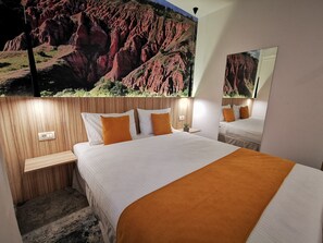 A hotel room with a large bed, two nightstands, a mirror, and a wall mural of a red rock landscape. - Ymy Boutique Residence (Bucharest)