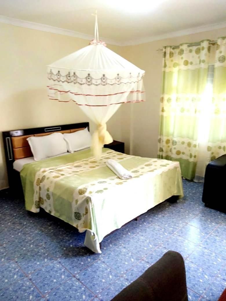 Ein Schlafzimmer mit Bett, Baldachin, Nachttisch und einem Fenster mit Vorhängen.
