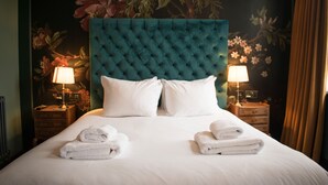 A neatly made bed with white linens and two towels folded at the foot. - Westow House - London Crystal Palace (London)