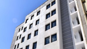 Ein modernes Hotelgebäude mit einer glatten Fassade, großen Fenstern und einem Schild, das es als Hotel kennzeichnet.