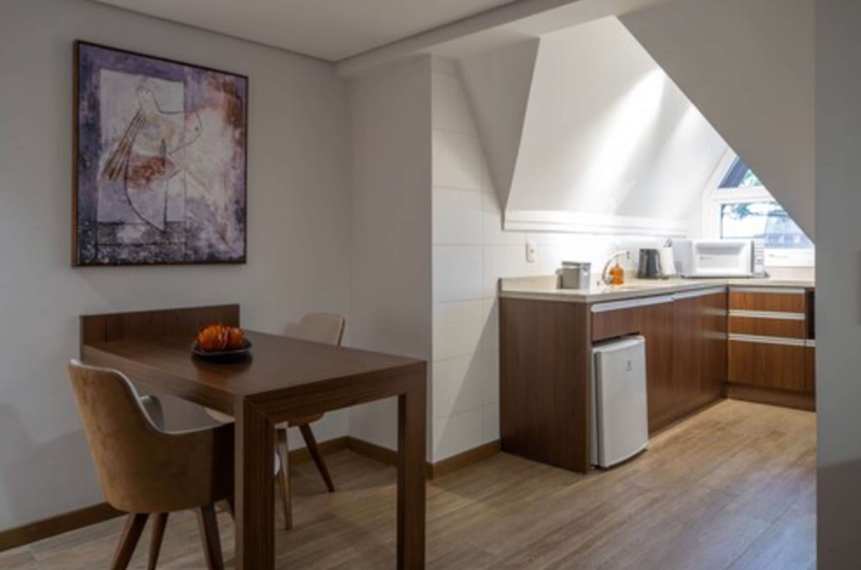 Eine moderne Küche mit einer Holz Arbeitsplatte, einem eingebauten Backofen und einem Kühlschrank.