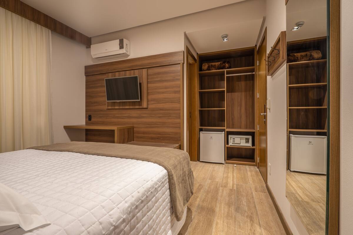A bedroom with a bed, built-in wardrobe, and a television.