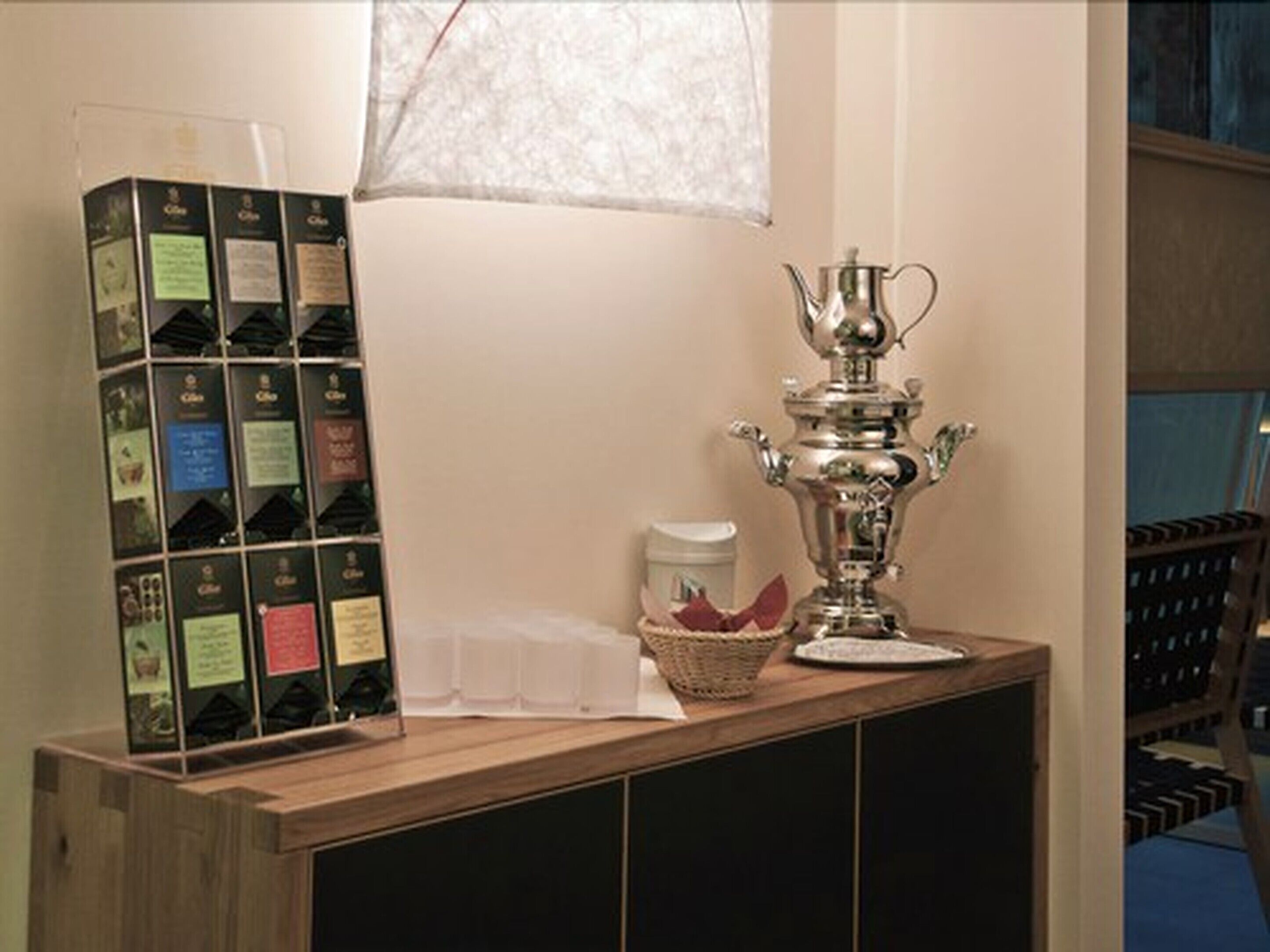 Eine Holztresen mit einer silbernen Trophäe, einem Korb und einer Auswahl an Kaffeeboxen.