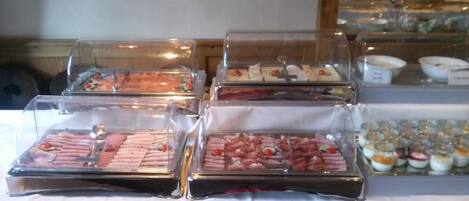 A buffet with various food items in clear containers.