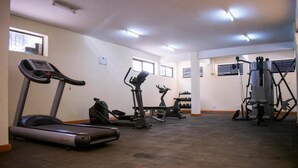 A gym with treadmills, elliptical machines, and weight equipment. - Celestial Luxury Homestay (Syokimau)