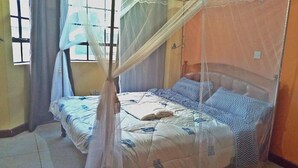 A single bed with a canopy, a window with curtains, and a tiled floor. - Celestial Luxury Homestay (Syokimau)