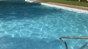 A clear swimming pool with visible water patterns and a metal pool ladder. - Camping Pirinenc (Campdevanol)