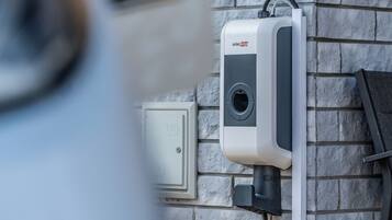 A solar panel system mounted on a stone wall.
