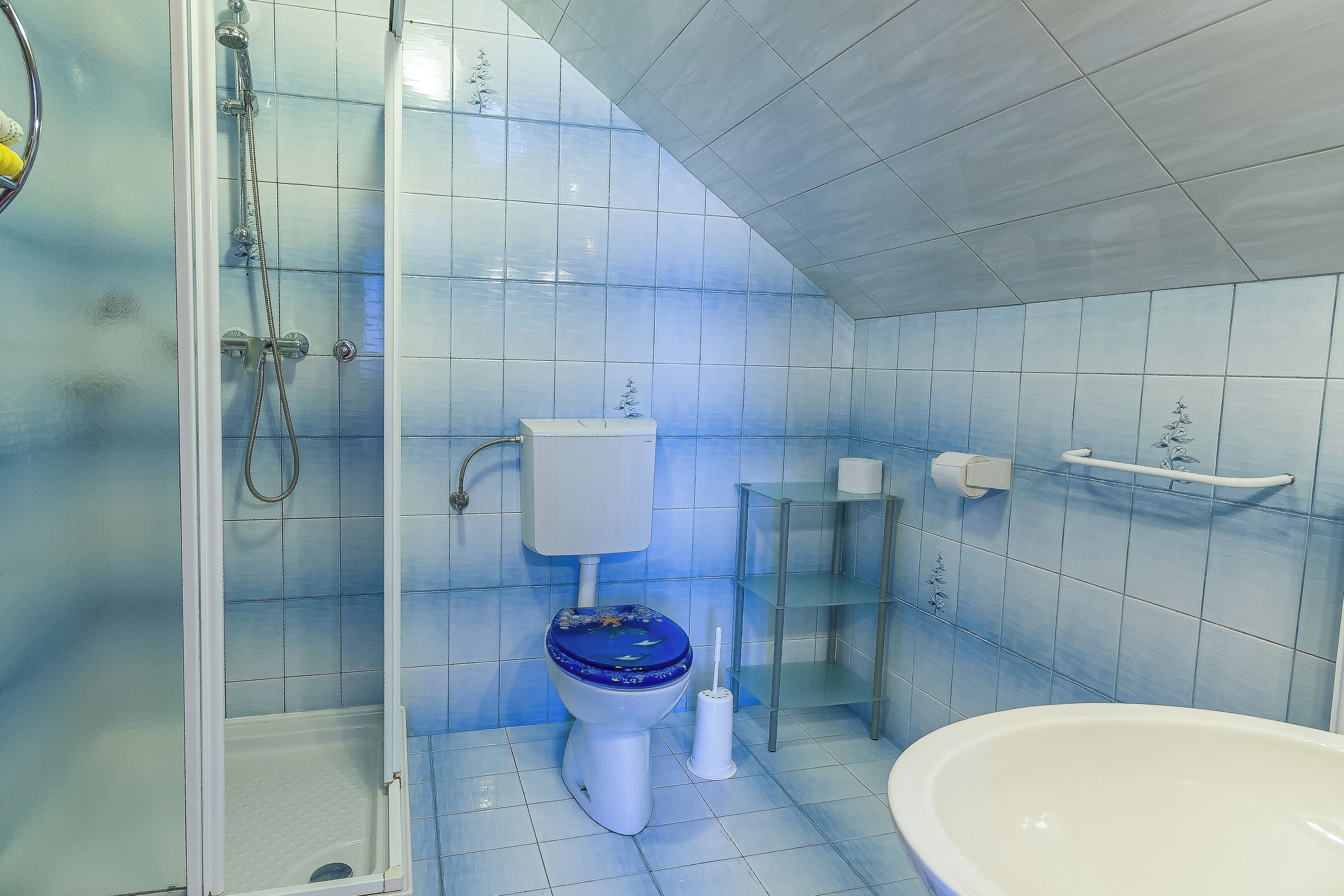 A bathroom with a shower, toilet, and sink.