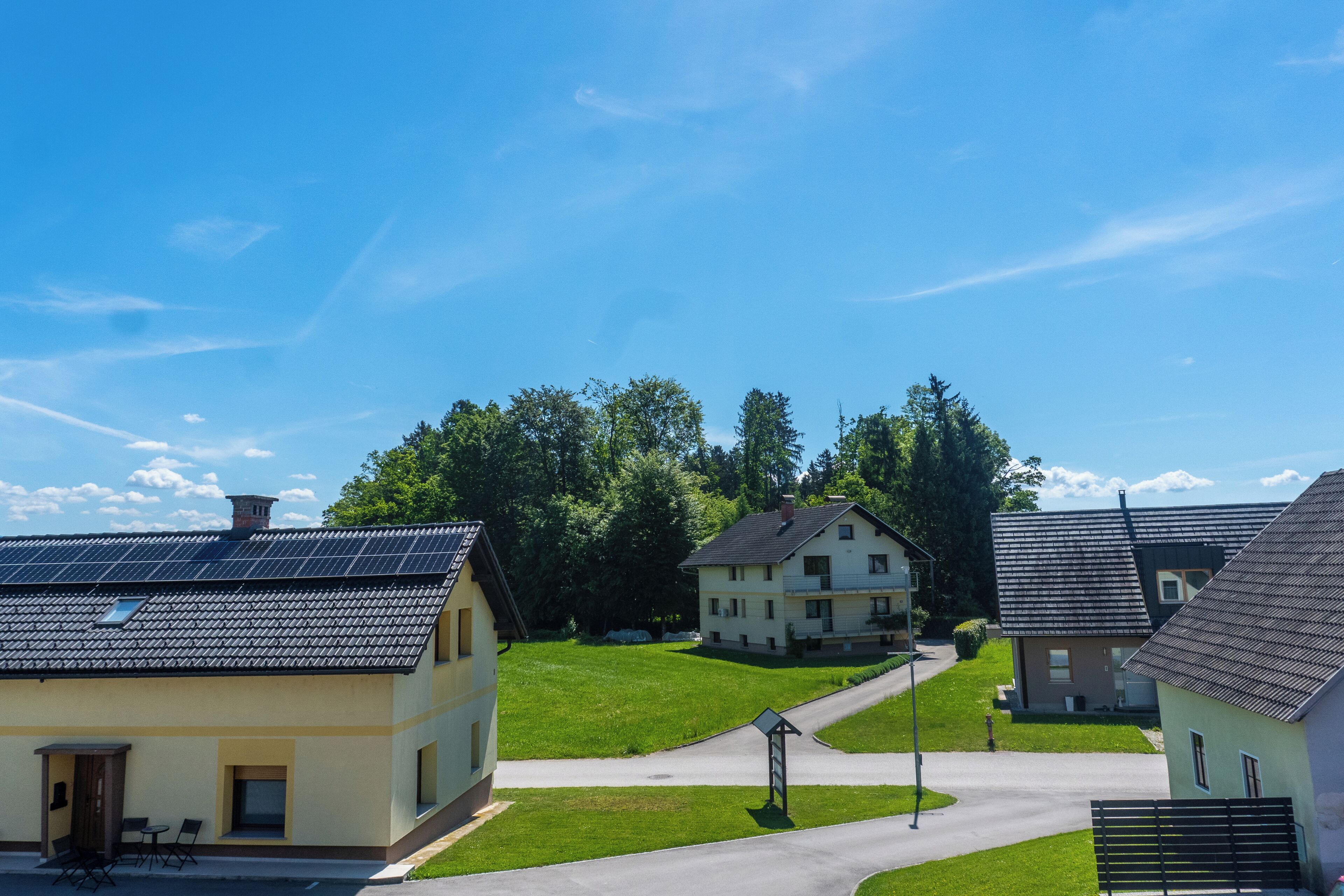 A residential area with houses, a clear sky, and a well-maintained lawn.