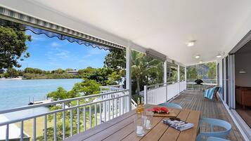 Enjoy a serene view of the calm water and lush surroundings from this balcony.