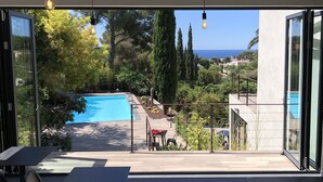 A modern outdoor space with a pool, seating area, and a view of the sea. - The Address Cassis (Cassis)