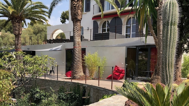 A modern house with a pool, palm trees, and red chairs. - The Address Cassis (Cassis)