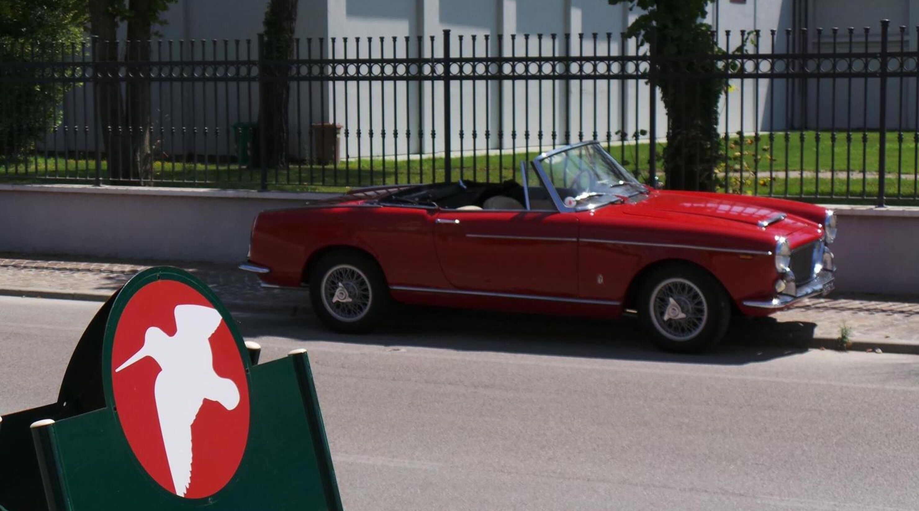 A red convertible car parked on a street.