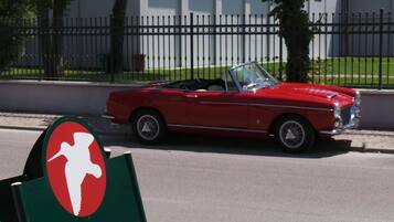 A red convertible car parked on a street.