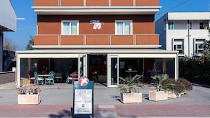 A two-story building with a signboard for a restaurant named "ASPORTO" offering pizza and pasta. - Albergo Italia (Porto Tolle)