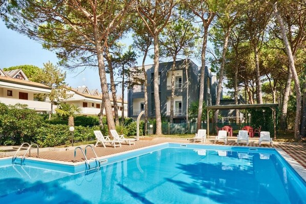 En säsongsöppen utomhuspool och solstolar