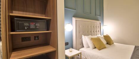 Ein Hotelzimmer mit Bett, Nachttisch, integriertem Fernseher und Minibar.