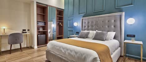 A modern bedroom with a large bed, a desk, and a wardrobe.