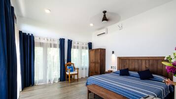 A bedroom with a wooden bed, a bench, a chair, and a bedside table.