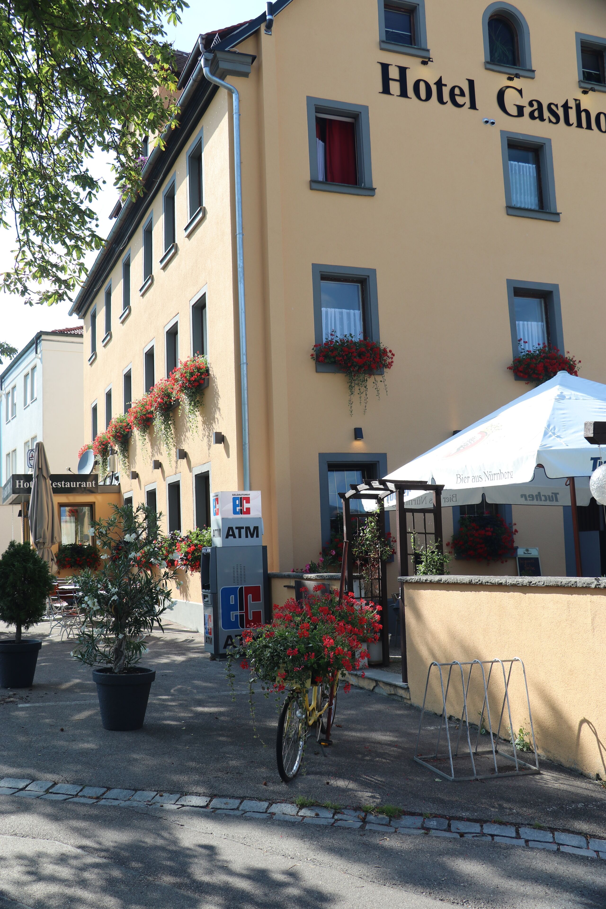 A hotel with a sign reading "Hotel Gastone" and a visible ATM.