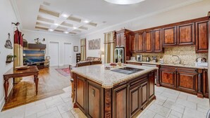 A spacious kitchen with a large island, wooden cabinets, and a modern ceiling design. - VIP Accommodations (Hollywood)