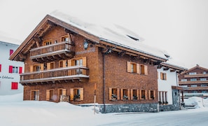 Un immeuble en bois à plusieurs étages, avec une enseigne indiquant « BENTLEYS HOUSE » et des balcons.