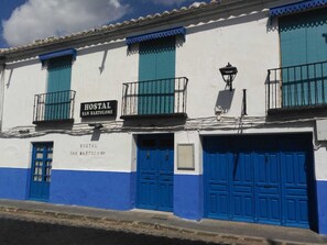 A building with a sign reading "Hostal San Bartolome" and blue doors. - Hostal San Bartolomé (Almagro)