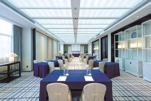 A conference room with a long table, chairs, and a projector screen. - Hotel Unic (NANJING)
