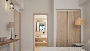 A bedroom with a bed, bedside table, lamp, and a wardrobe. - Gerakas Luxury Villas (Zakynthos)