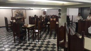 A restaurant with a checkered floor, wooden chairs, and tables. - Hotel Central (Belém)