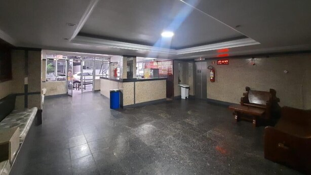 A spacious lobby with a reception desk, a trash bin, and a fire extinguisher on the wall. - Hotel Central (Belém)