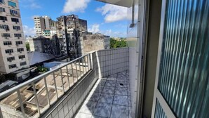 A balcony with a metal railing, a tiled floor, and a view of surrounding buildings. - Hotel Central (Belém)